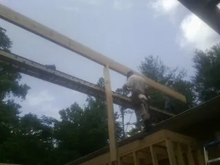 Carpenter setting a ridge beam over a new addition frame — Ice Dam Removal by Roofing Brothers in Burgettstown