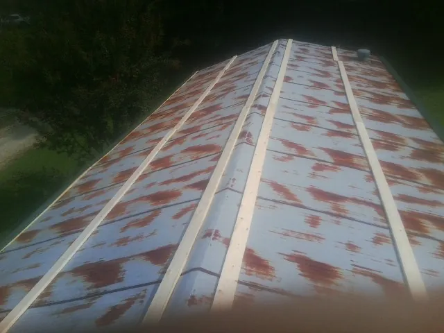Rusted metal roof panels with new wood purlins before replacement — Storm Damage Roof Repair in Burgettstown by Roofing Brothers