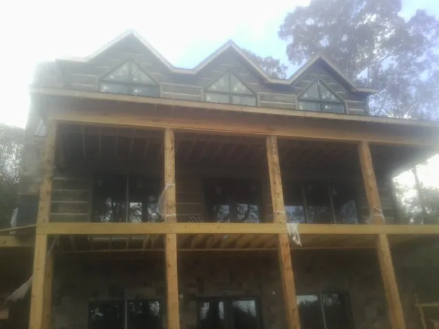 Dormers and porch framing on a large log home under construction — Roof Coating work by our crew in Burgettstown