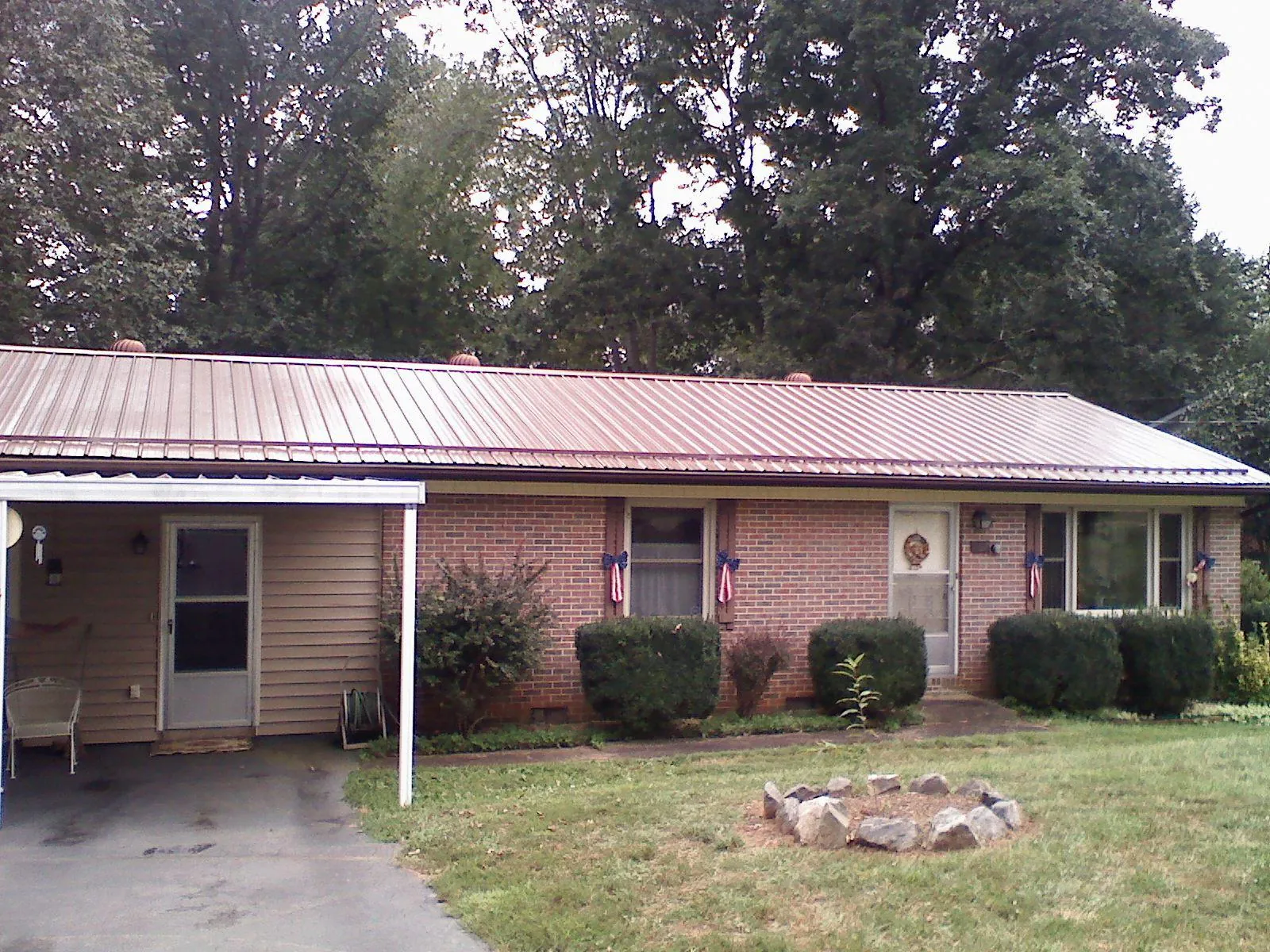 Bronze metal roof and carport on a brick ranch home — Roof Repair work by our crew in Burgettstown